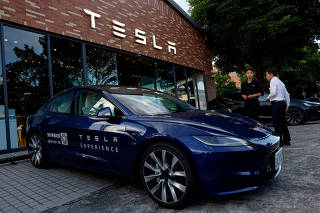 People outside a Tesla showroom in Taipei