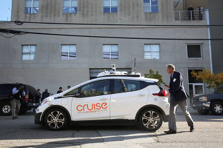 FILE PHOTO: A journalist gets in a self-driving GM Bolt EV during a media event in San Francisco