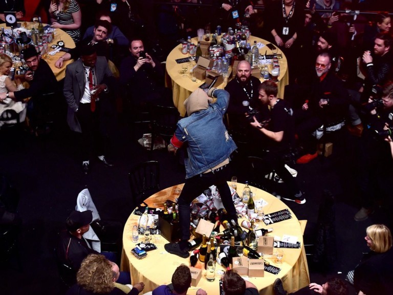 Oli Sykes, vocalista da Bring Me The Horizon, sobre na mesa do Coldplay em apresentação