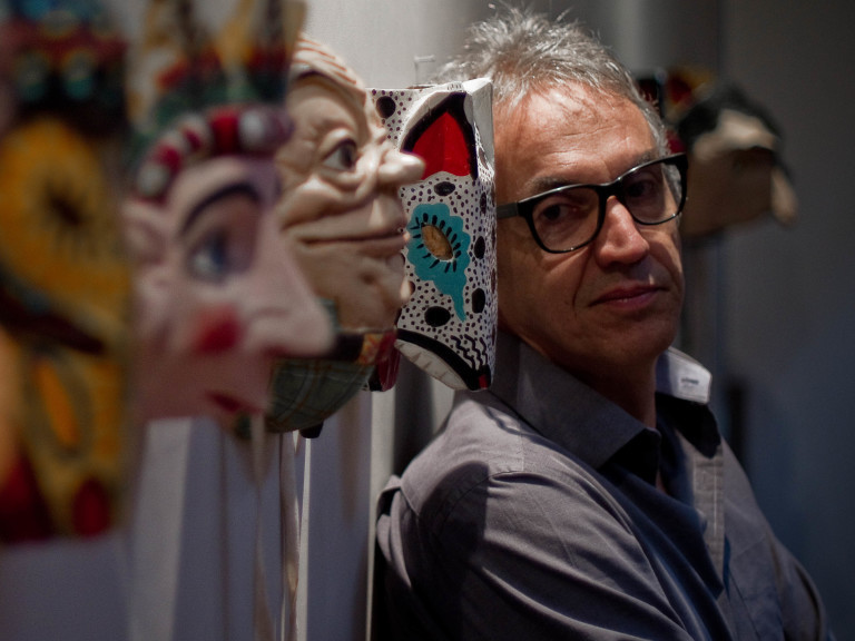 O roteirista e cartunista Claudio Paiva posa para foto entre máscaras, em sua residencia na Urca, zona sul do Rio de Janeiro (RJ)