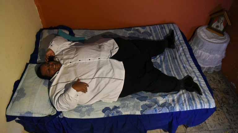 Oscar Vasquez Morales, 44, considered the most obese male of the country with about 400 kg, speaks through his mobile on May 16, 2016 in Cali, Colombia, before being transferred to a clinic to get a gastric balloon implanted with which his weight is expected to reduce to 300 kg. / AFP PHOTO / LUIS ROBAYO ORG XMIT: LRO004