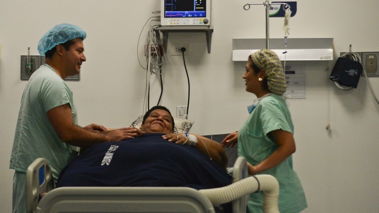 Oscar Vasquez Morales (C), 44, considered the most obese male of country with about 400 kg, gestures next to bariatric surgeon Juan del Castillo (L)on May 16, 2016 in Cali, Colombia, at the clinic where he will get a gastric balloon implanted with which his weight is expected to reduce to 300 kg. / AFP PHOTO / LUIS ROBAYO ORG XMIT: LRO007