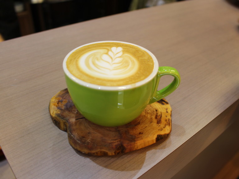 Em vez de pires, fatias de troncos de árvores (já inutilizadas) de café apoiam as xícaras na Um Coffee Co. 