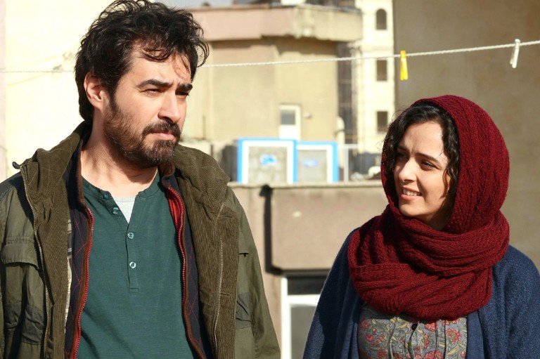 Um homem e uma mulher conversam em Teerã. Ela usa um lenço na cabeça e sorri